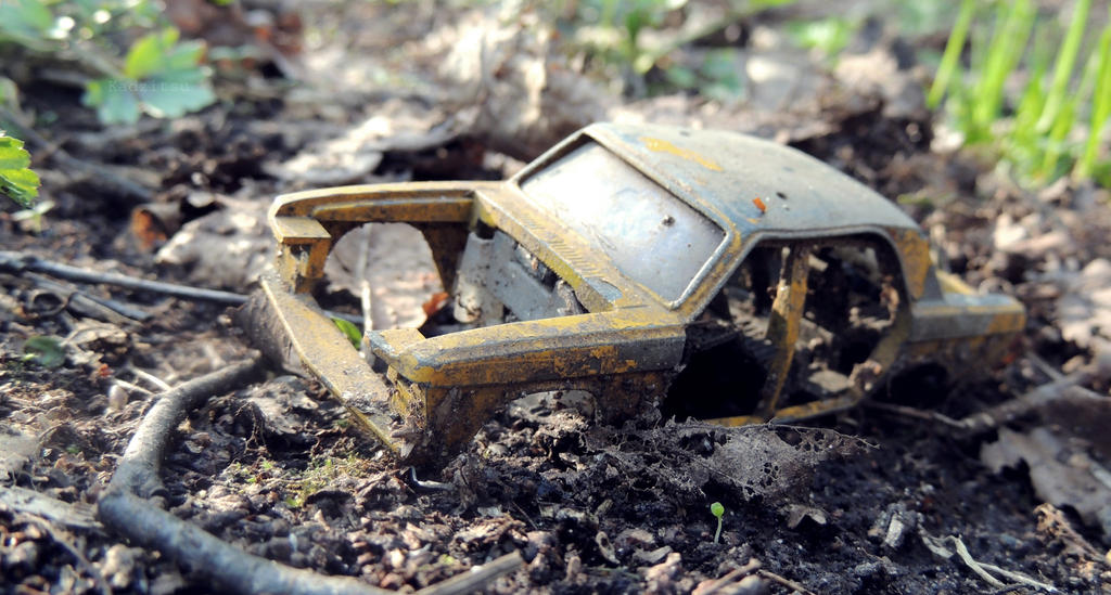 An broken, old dumped toy car.